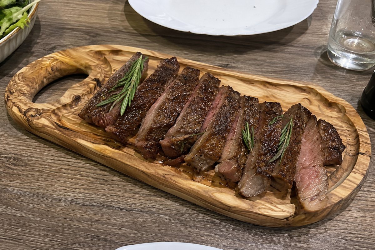 Steak daska od maslinovog drveta sa isečenim biftekom